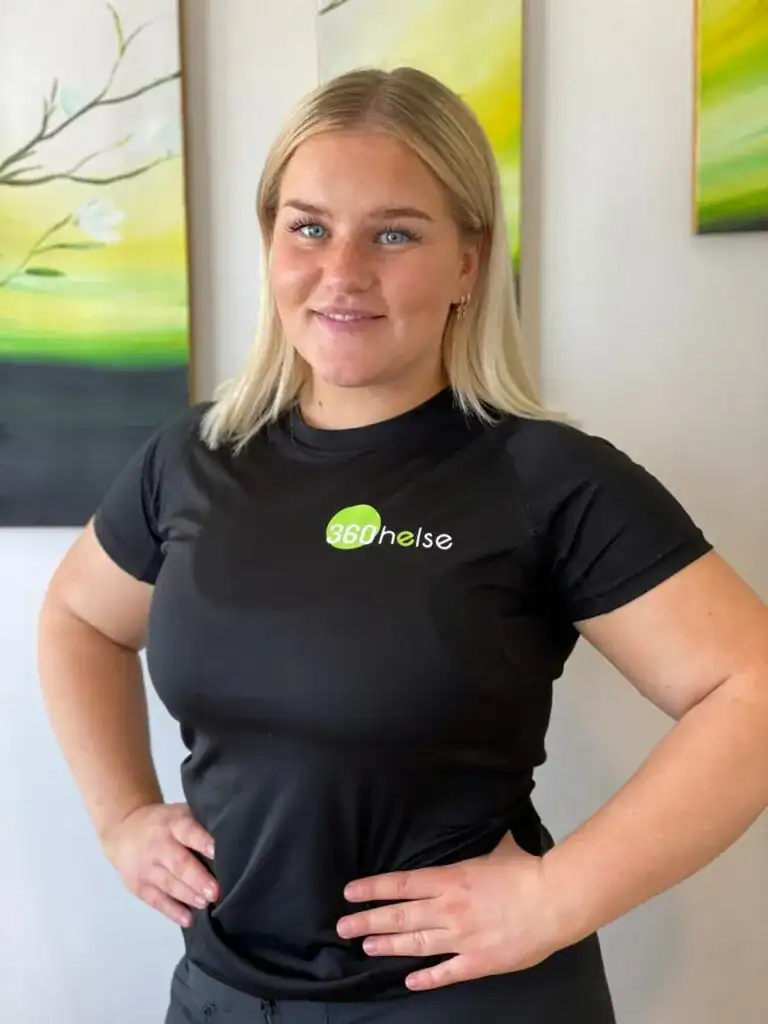 Helsepersonell i svart treningstøy med 360Helse logo, smilende og selvsikker, foran konstnærlige kunstverk, fokus på helse og velvære, optimalisert for helse- og velvære-søk.